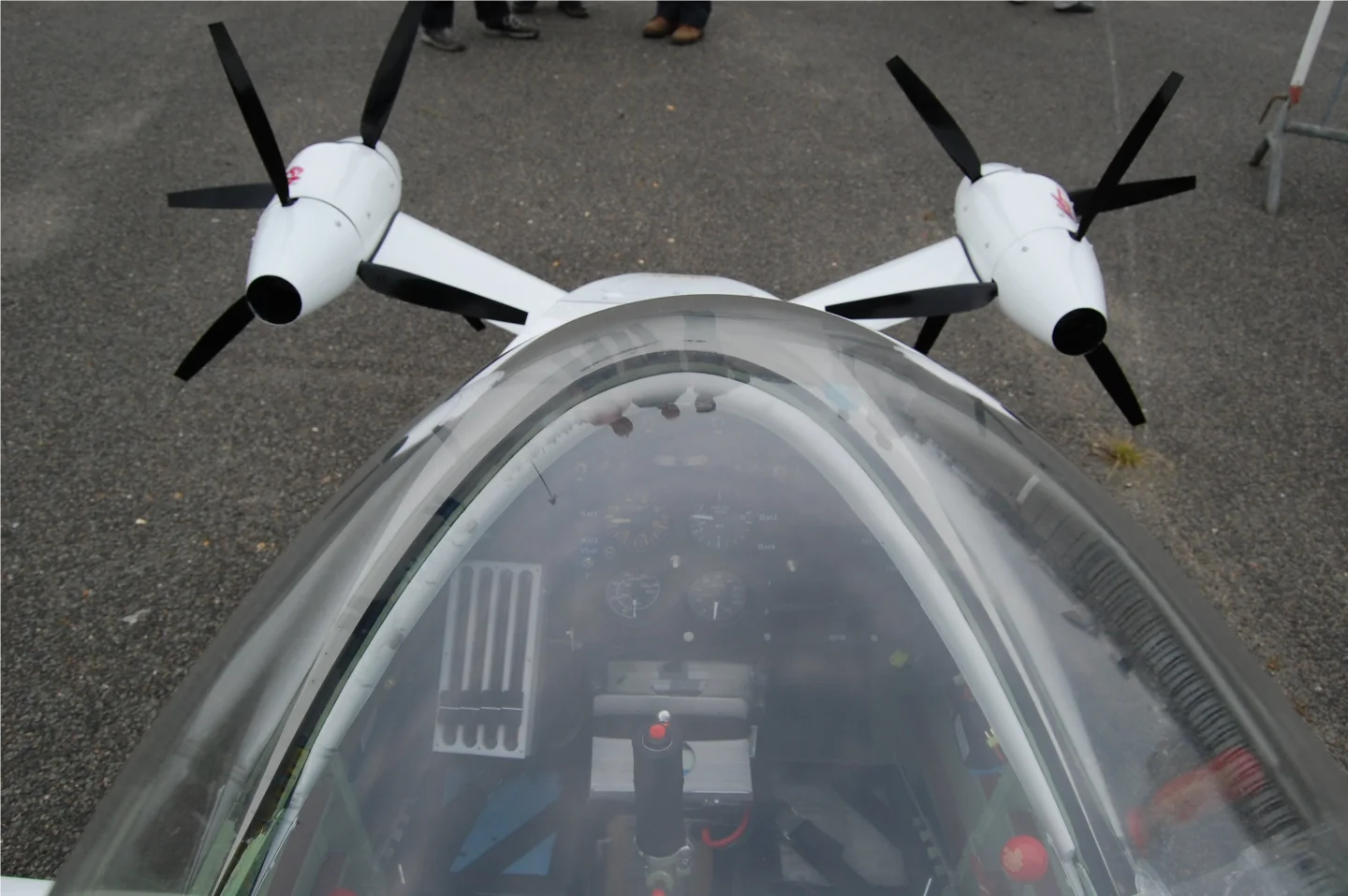 Over the top, showing the pilot compartment and the four electric engines each driving its own prop