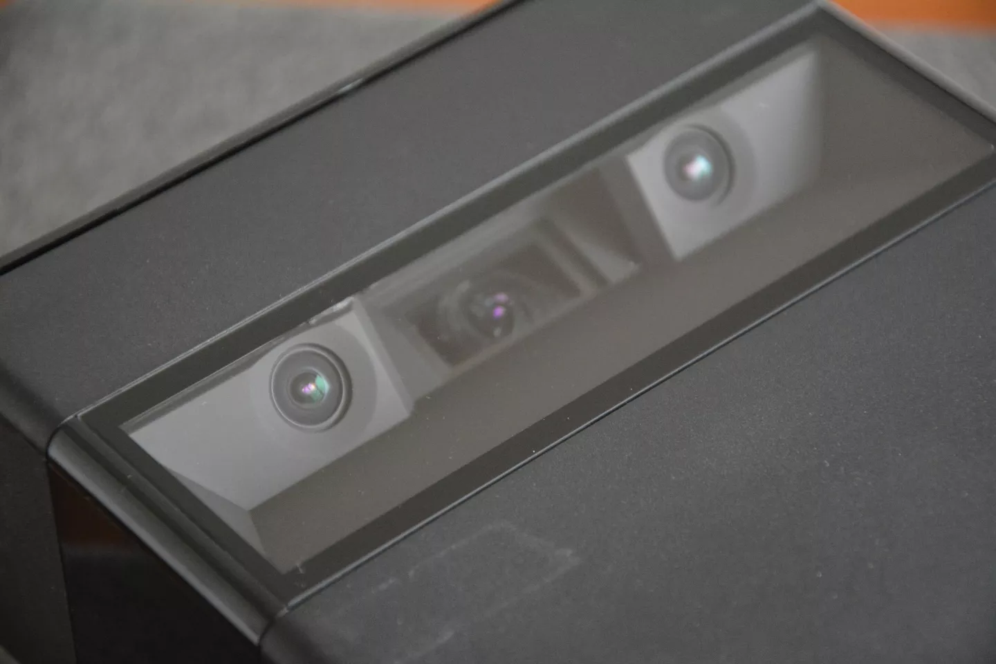 The projection module in the middle, flanked by the system's tracking sensors