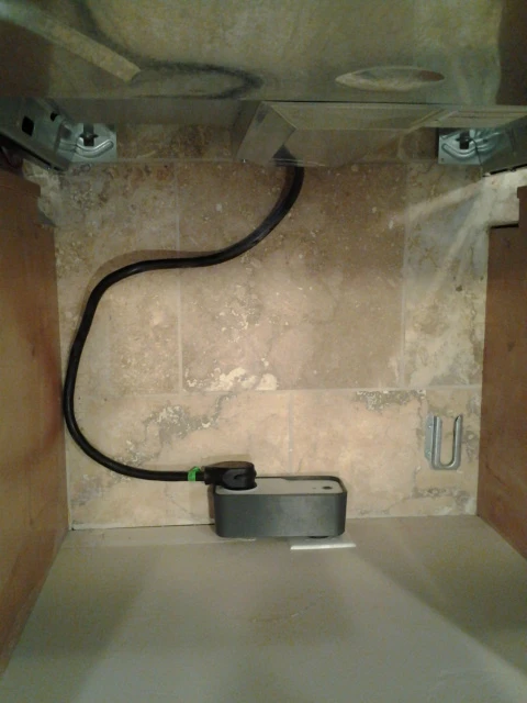 The Fire Avert sits between the stove and electrical outlet, cutting power when the smoke alarm rings