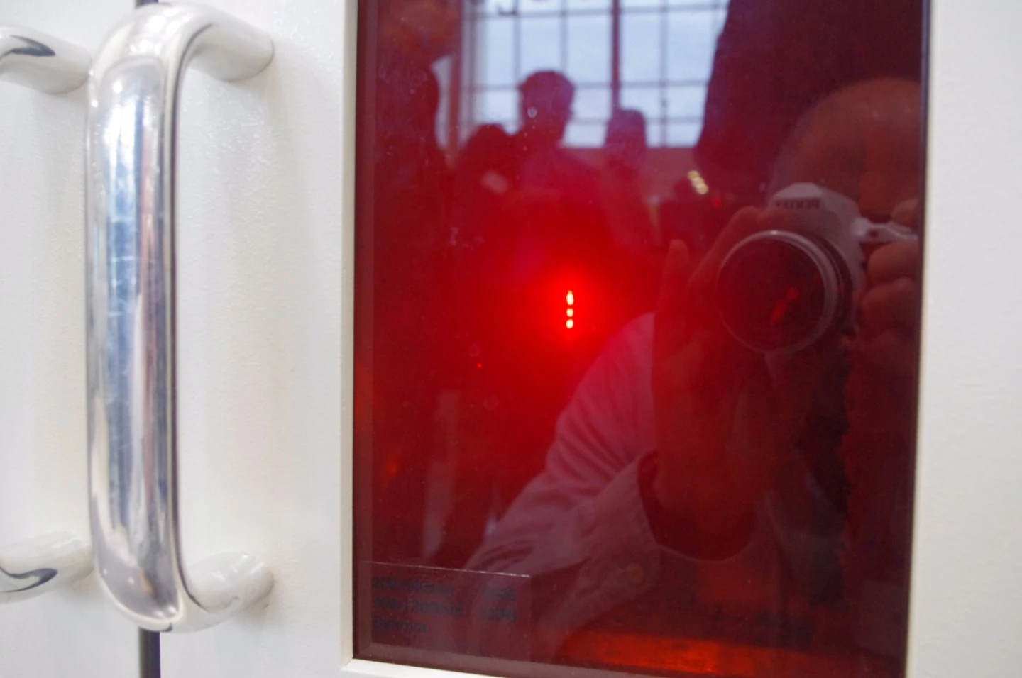 Behind the window, a laser wrapped in a jet of water is punching holes in a turbine part using the Laser MicroJet system