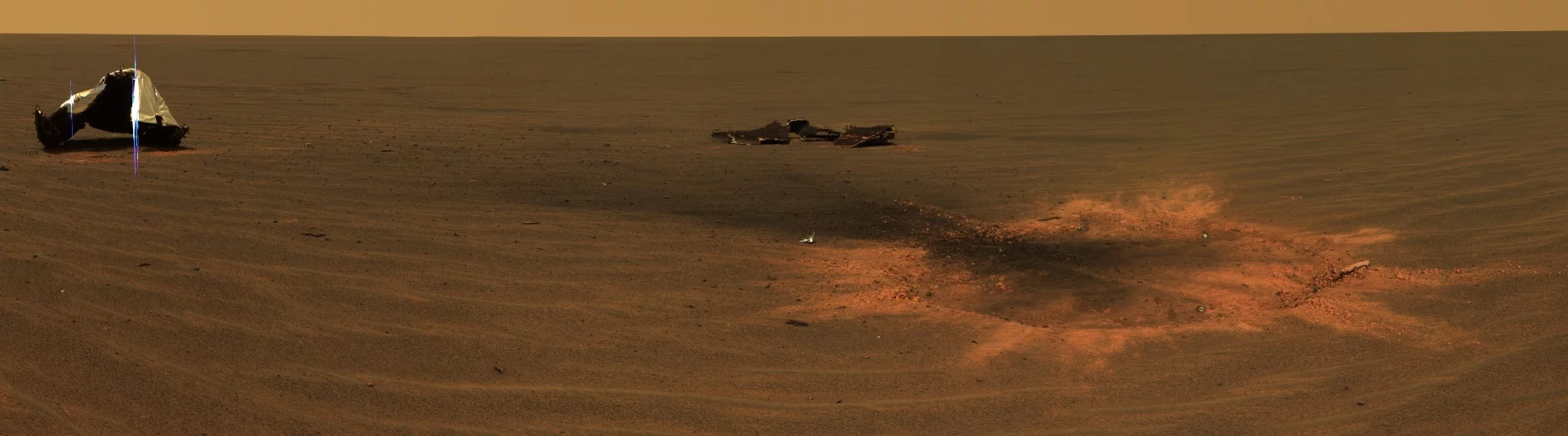 Opportunity landing site showing the discarded heat shield and a bounce crater caused by the impact of the lander