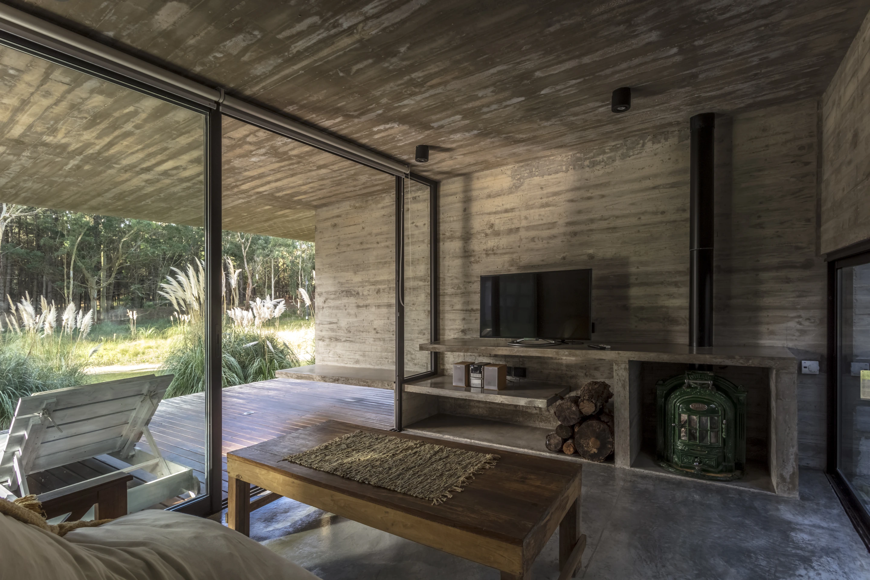 A living area opens up to a covered balcony in the Forest House, by Besonias Almeida