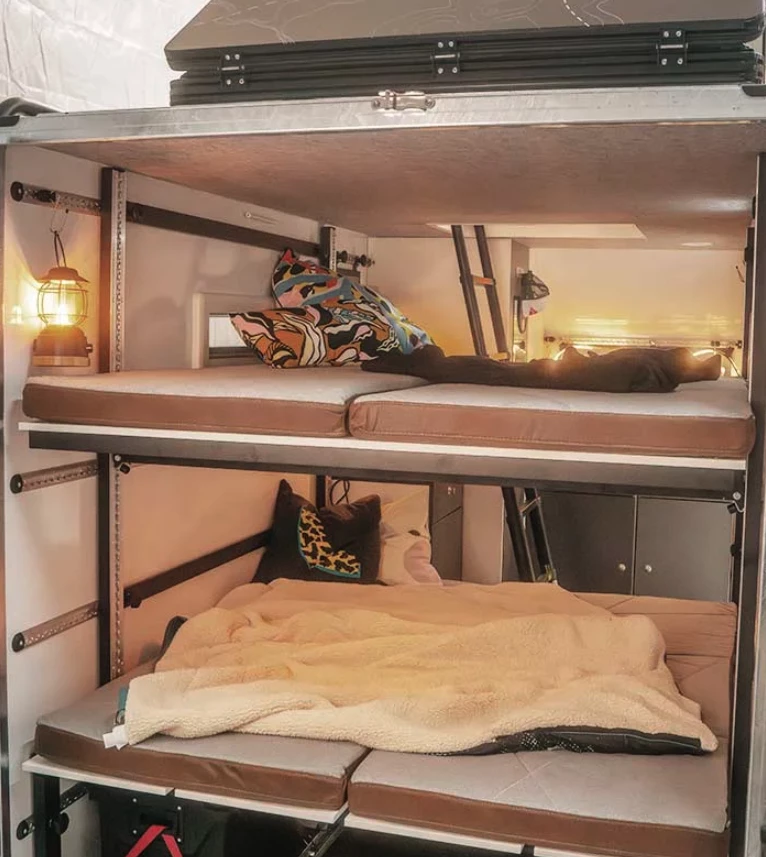 The triple sleeping stack includes the lower convertible dining bench bed, the upper foldaway bed and the rooftop tent accessible from the inner hatch