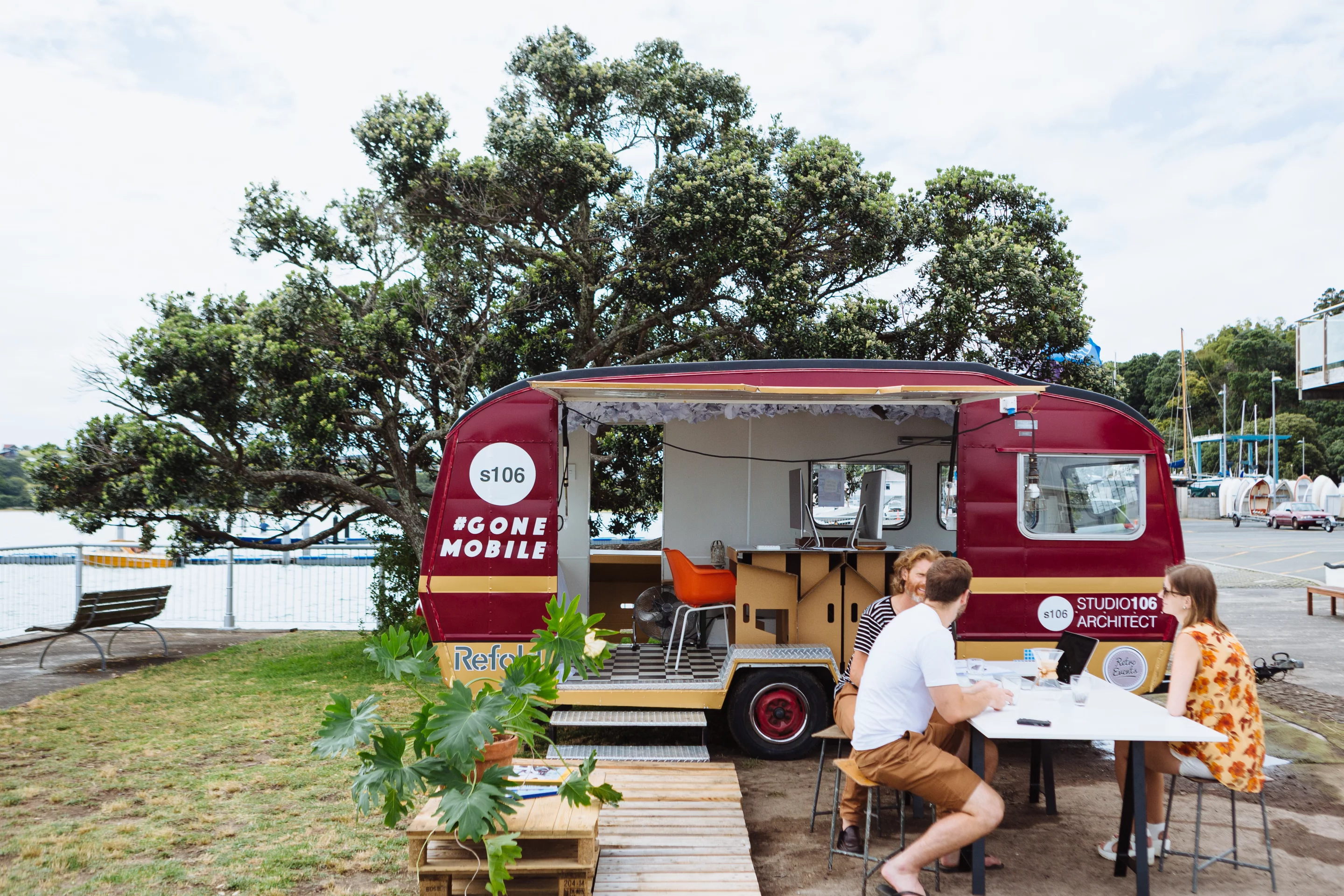The final result is a clean and fresh mobile office complete with a retractable wall, cardboard desks, outdoor furniture, computers and essential office equipment