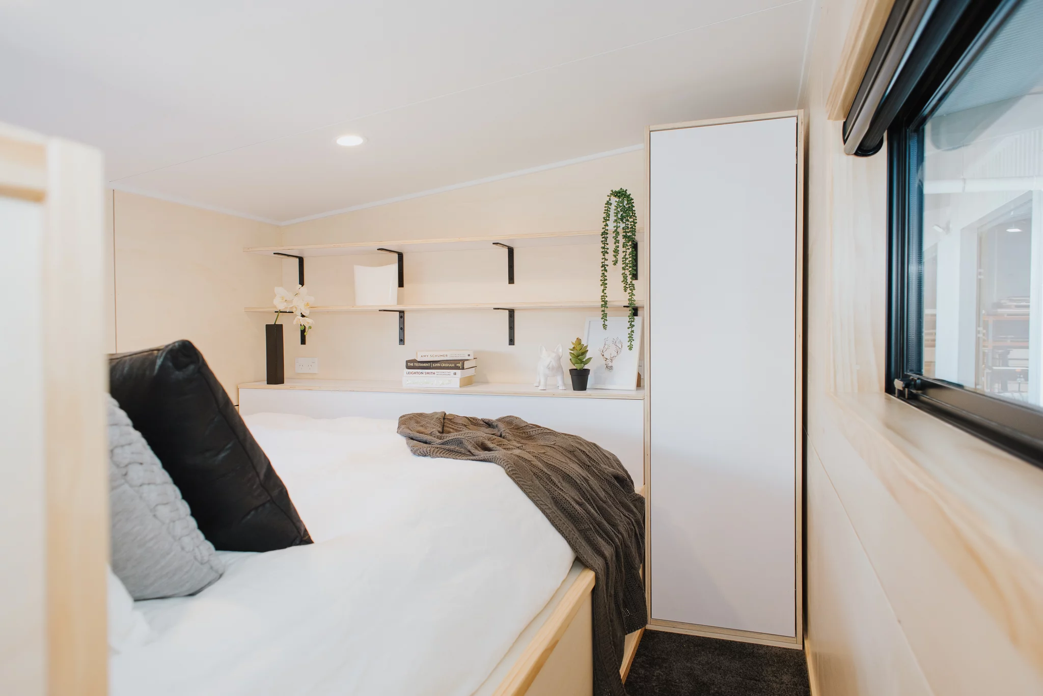 The Dreamweaver Tiny House's main bedroom has a lowered platform area, allowing people to stand up straight and making getting dressed a lot easier