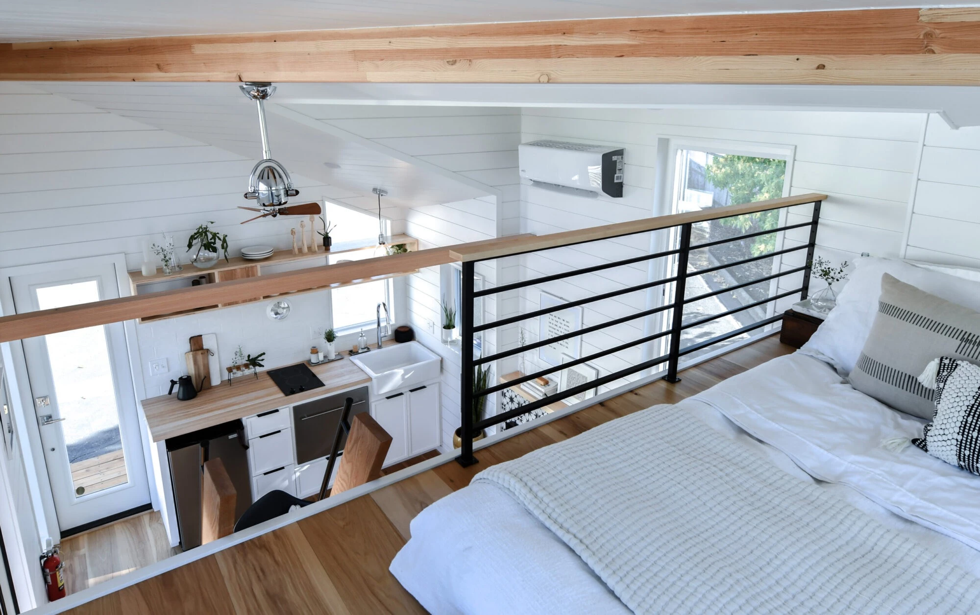 The Urban Park Studio's bedroom is a typical loft-based tiny house space with a low ceiling
