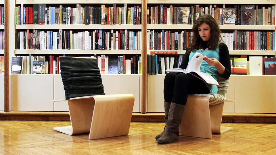 The LLSTOL chair as seen in a library, complete with textile cover