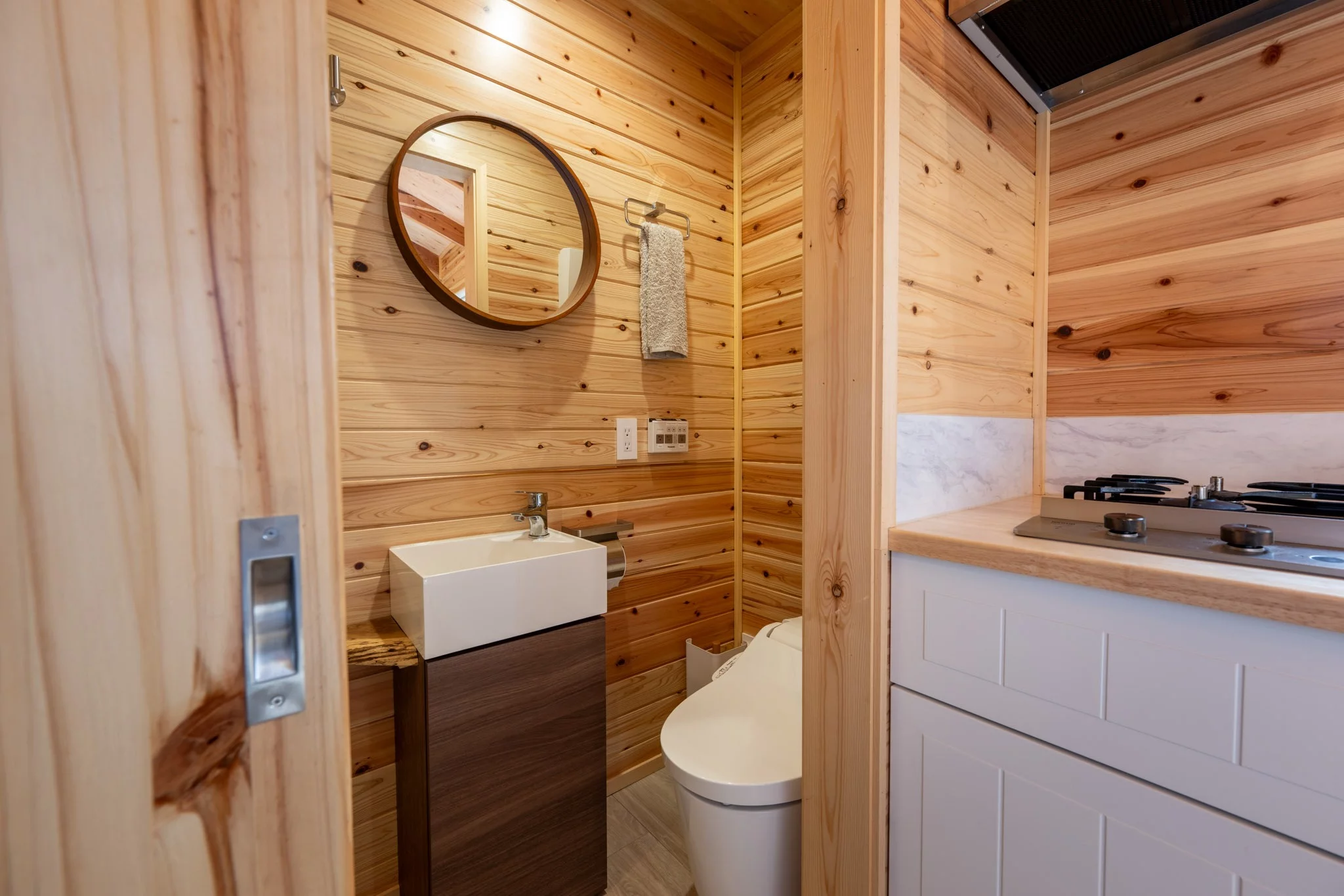 The Nozawa's bathroom includes a shower, a small sink, and a flushing toilet