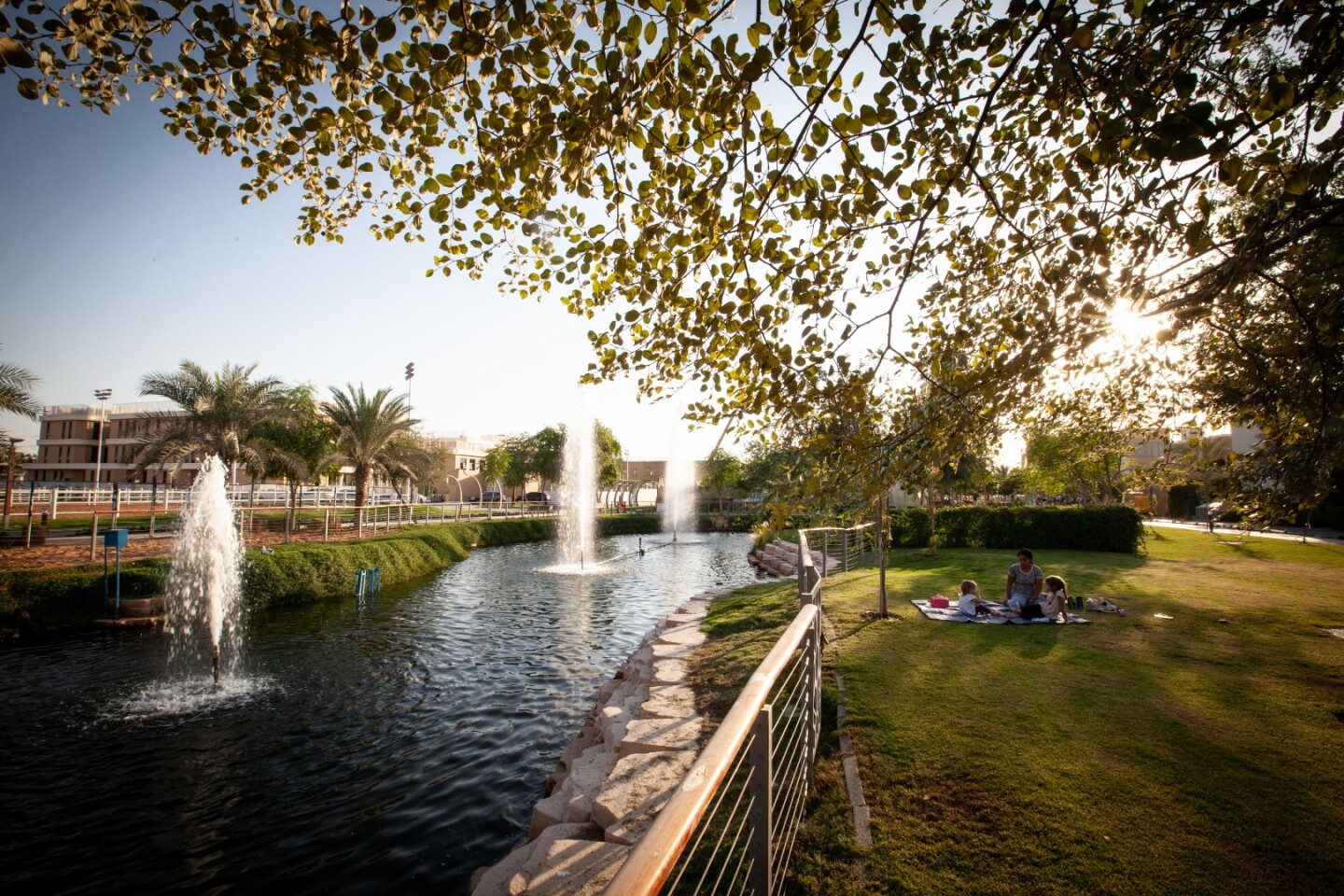 A family picnics by the water at the Dubai Sustainable City