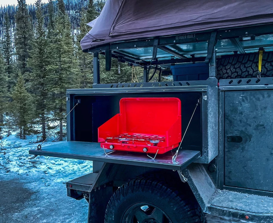 No hard-plumbed stove, but the bolt-on side box can serve as a functional kitchen with help from the slide-out cooler or fridge