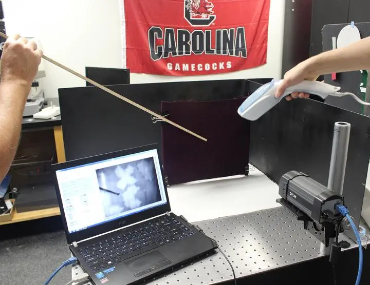 A hand steamer and an infrared camera are used to reveal blood markings on a black background