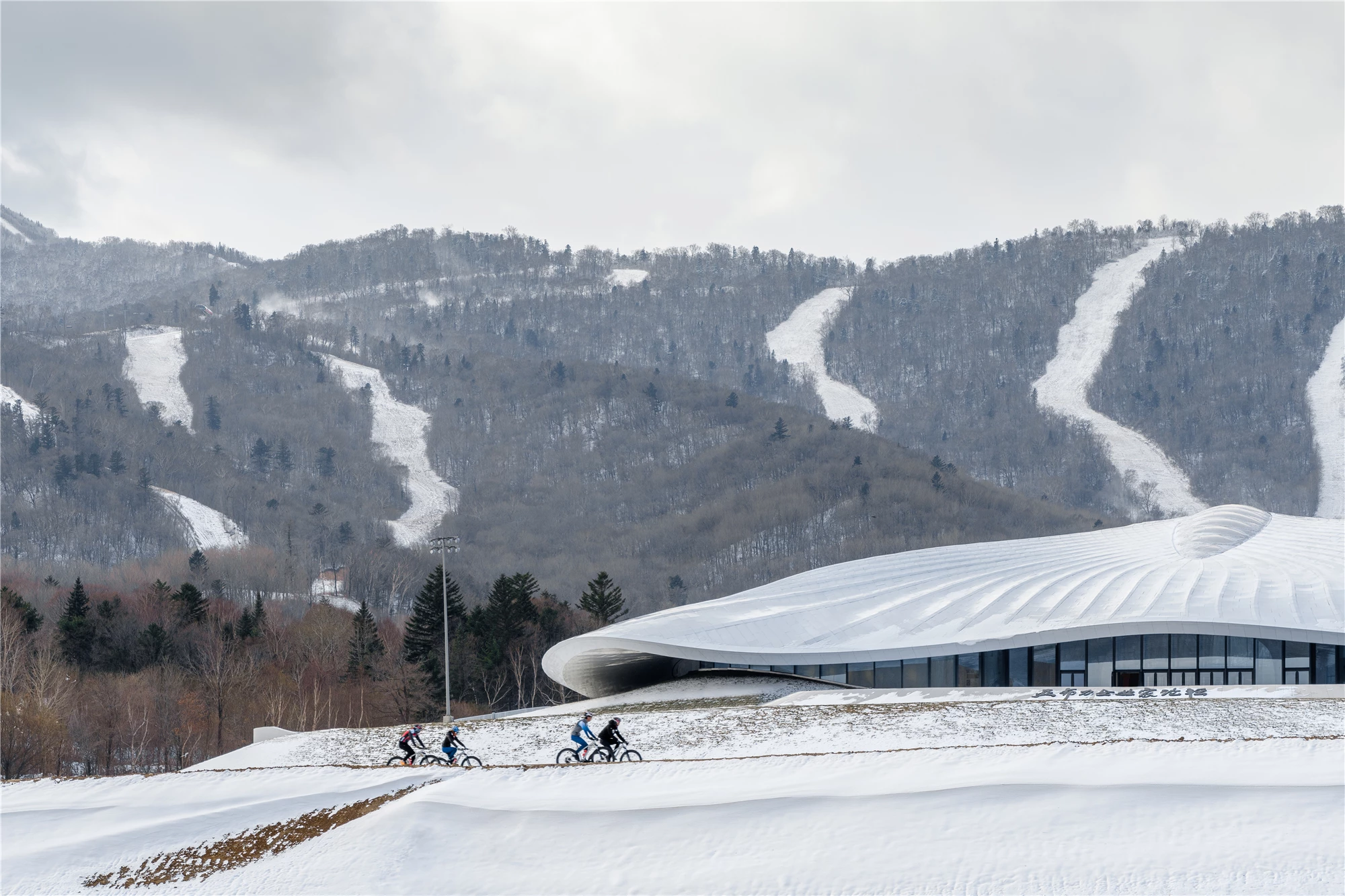 The Yabuli Entrepreneurs' Congress Center is topped by a large undulating roof that's designed to blend into the surrounding landscape