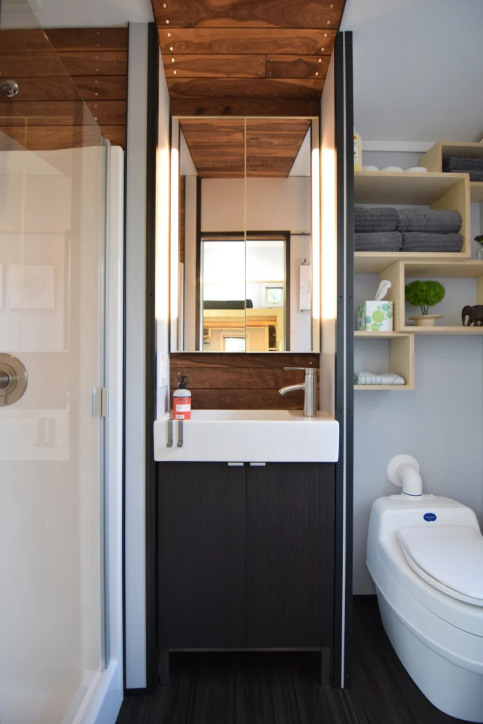 The bathroom includes a shower, sink, and composting toilet