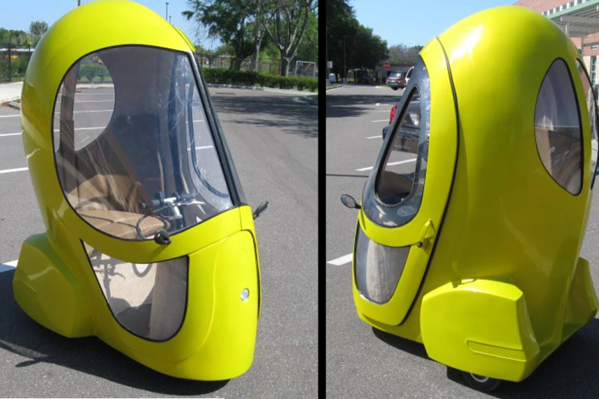 The Eggasus is a three-wheeled electric vehicle fitted with an electric hub motor, enclosed cab, tinted windows, a seat, and instrument display panel