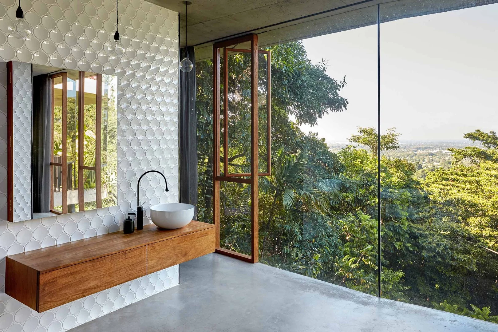 The Planchonella House uses the combination of greenery-covered roof, large sliding windows and concrete thermal mass to passively cool its interior