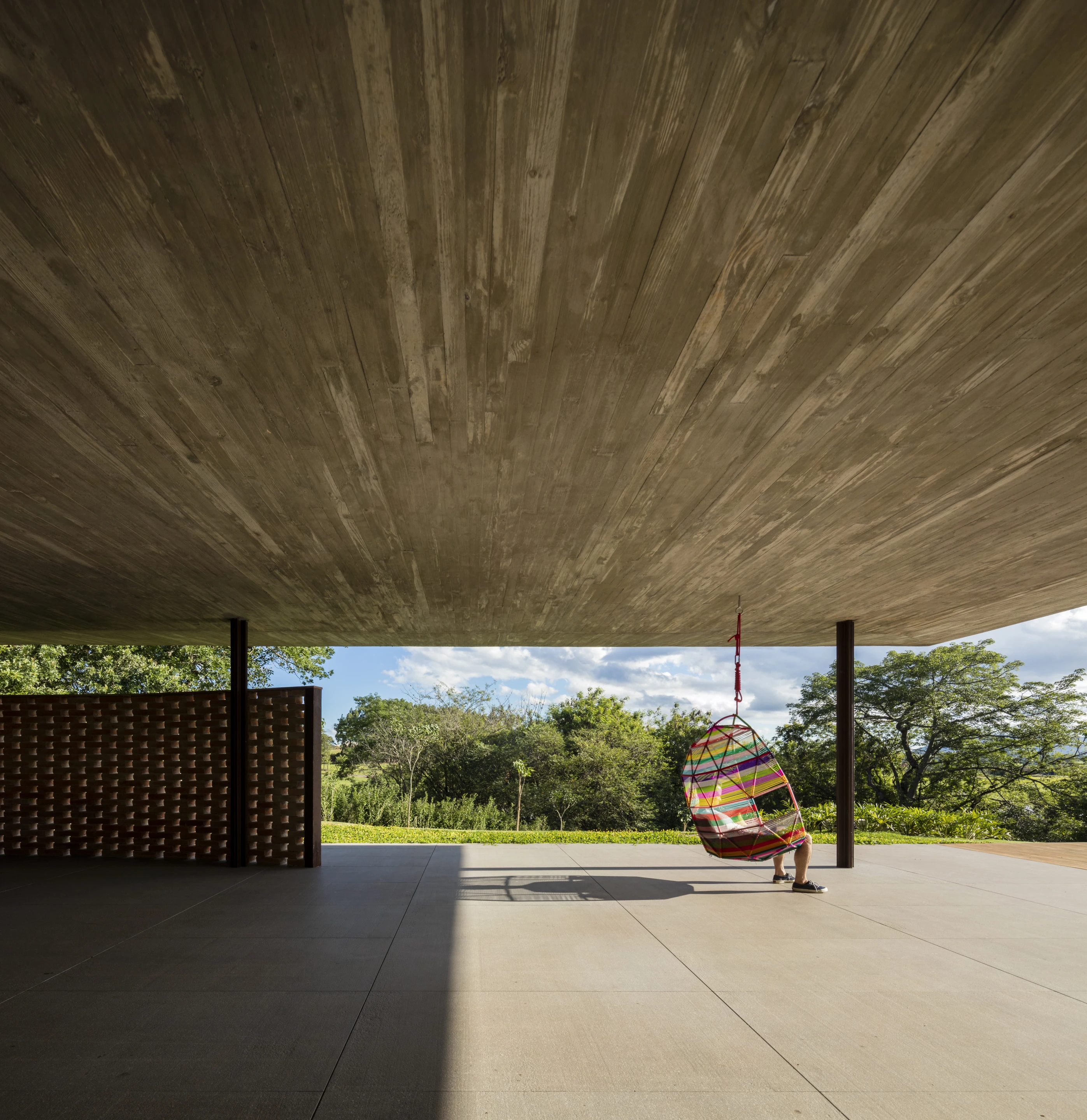 Planar House is defined by its massive concrete roof, which is covered in greenery