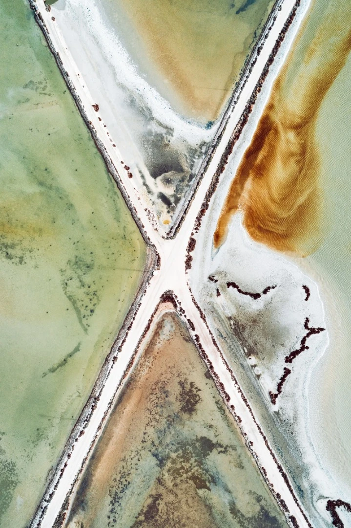 The Salt Series: Chronicling the harvesting of sea salt using artificially created ponds. The color of the water indicates the salinity of the ponds with micro-organisms changing their hues as the salinity of the pond increases