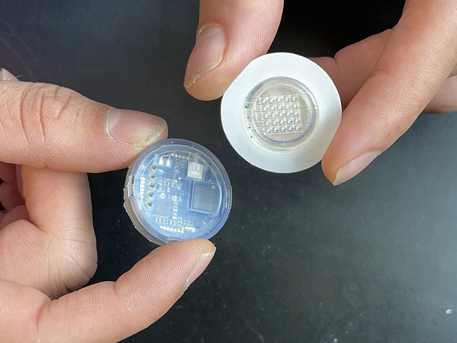 The reusable electronics case (left) can be separated from the microneedle array (right)