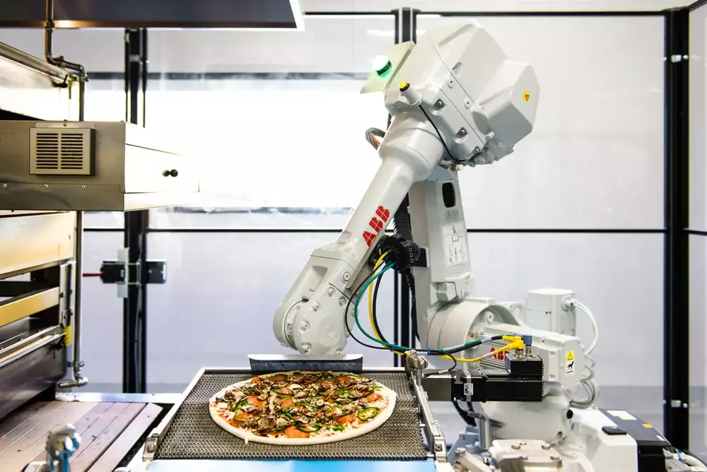 A Zume Pizza robot preparing to load a pizza into the oven