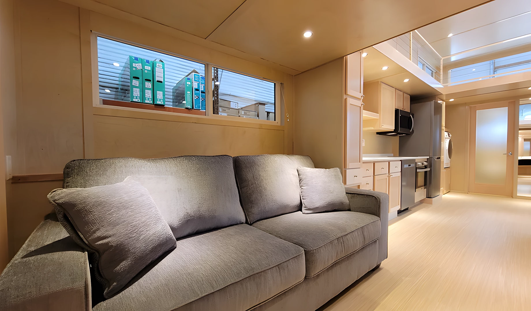 The Ultimate tiny house's living room includes a sofa and an entertainment center