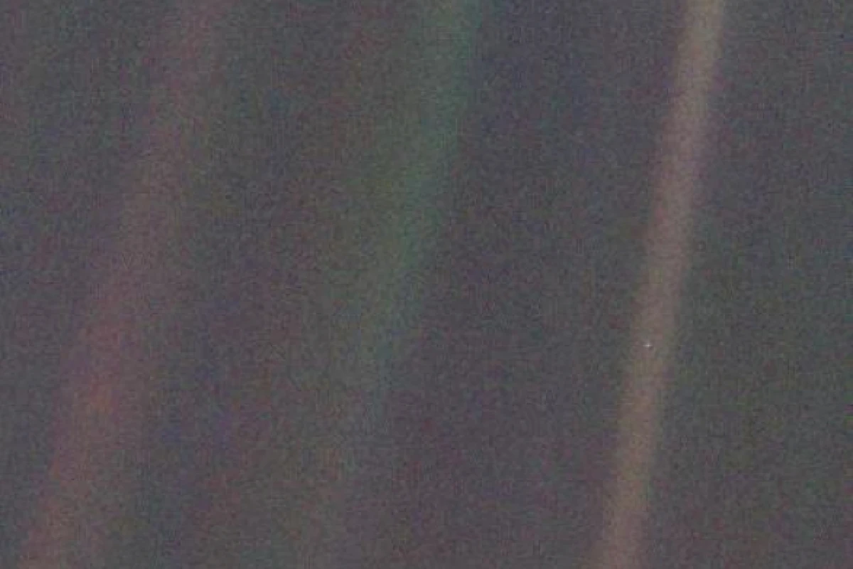 Voyager 1's iconic pale blue dot, with Earth featured as a tiny spec in the light band on the right of the image