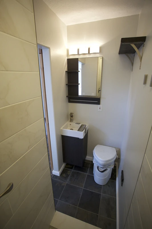 The bathroom includes a composting toilet and shower