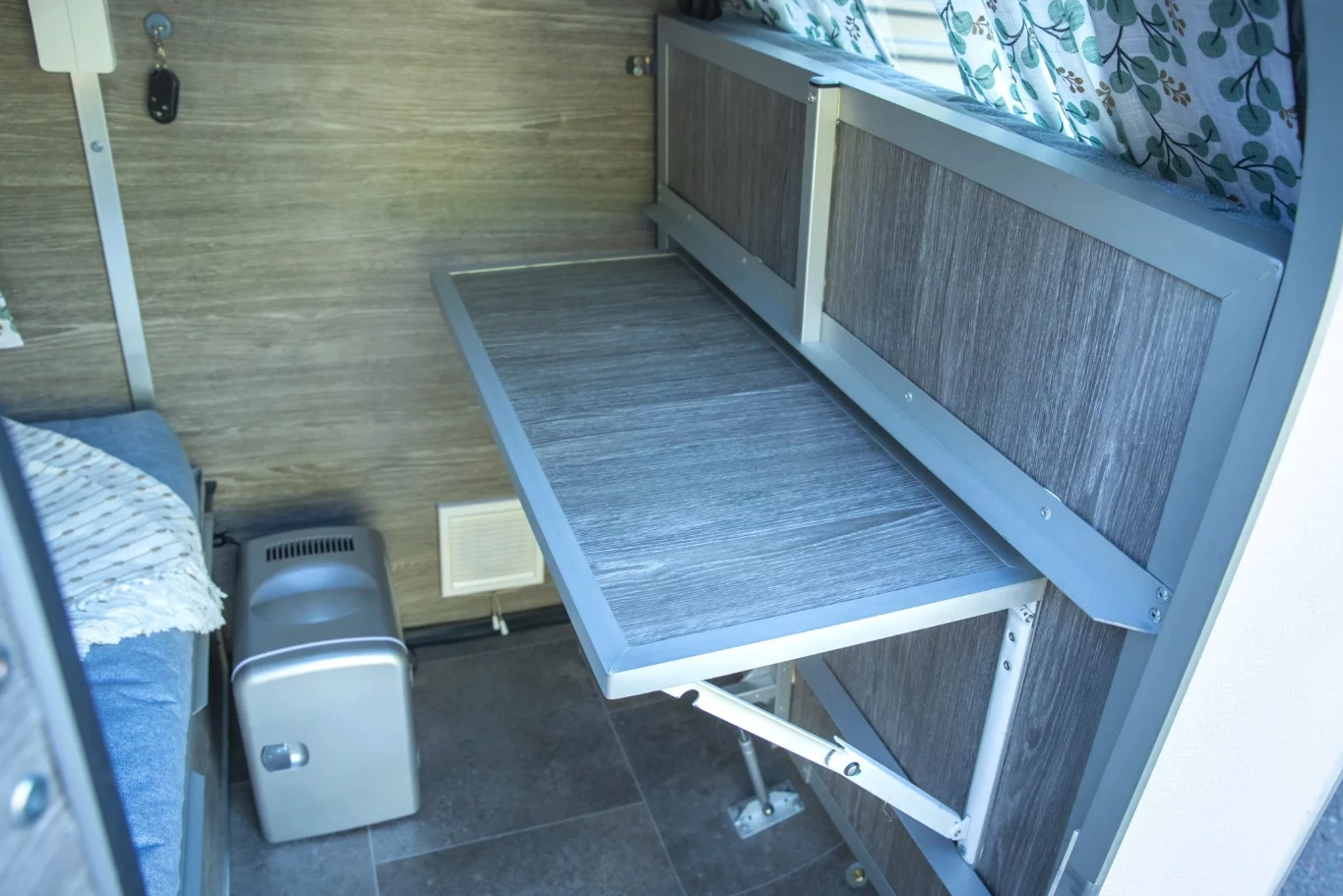 During the day, the end of the bed folds out of the way to create an entryway and dining area/workstation