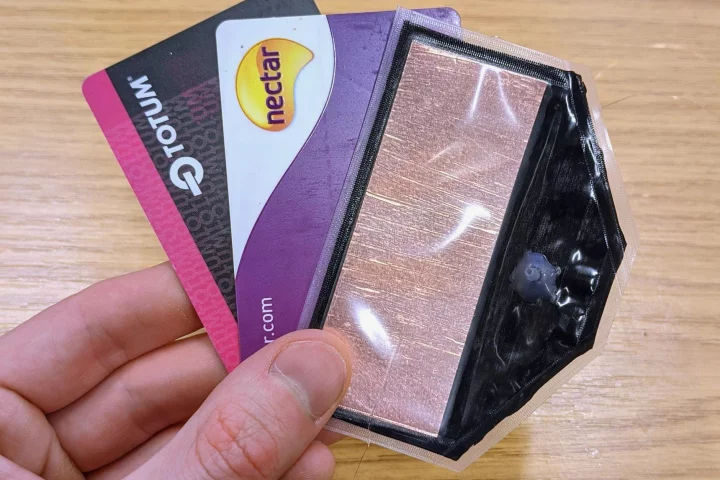 The electro-pneumatic pump (right) along with wallet cards for scale