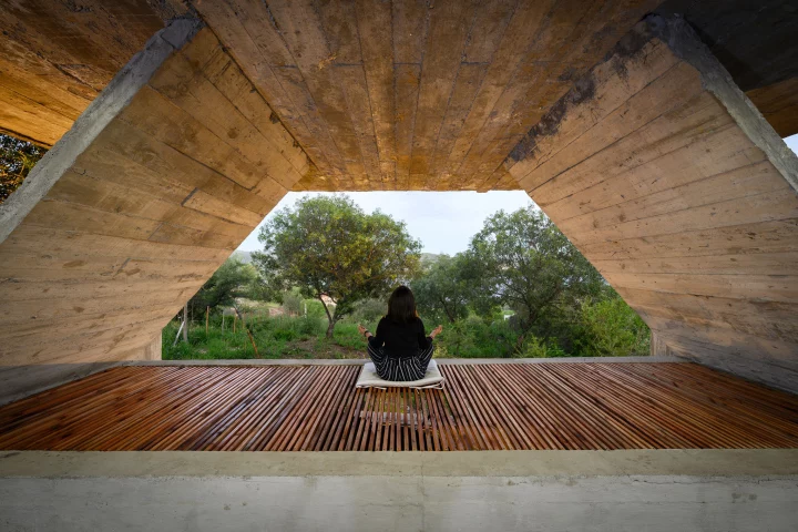 Hanging beneath the home's swimming pool is a triangular open-air yoga space