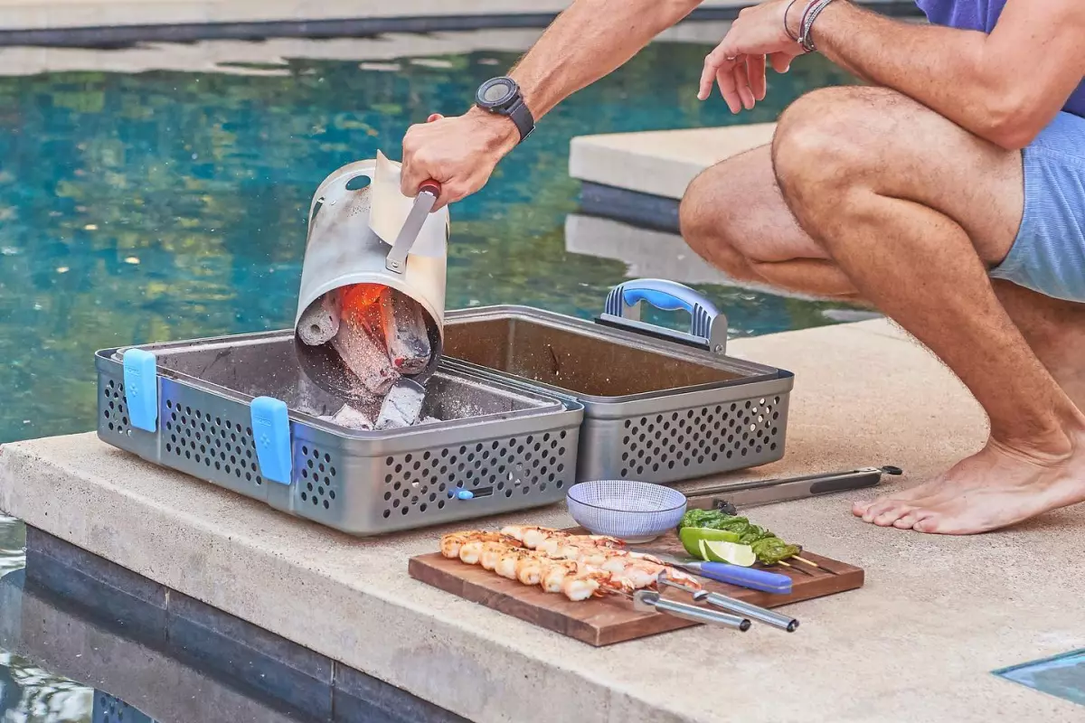 Folded open, the cooker features two empty beds that can be filled with charcoal