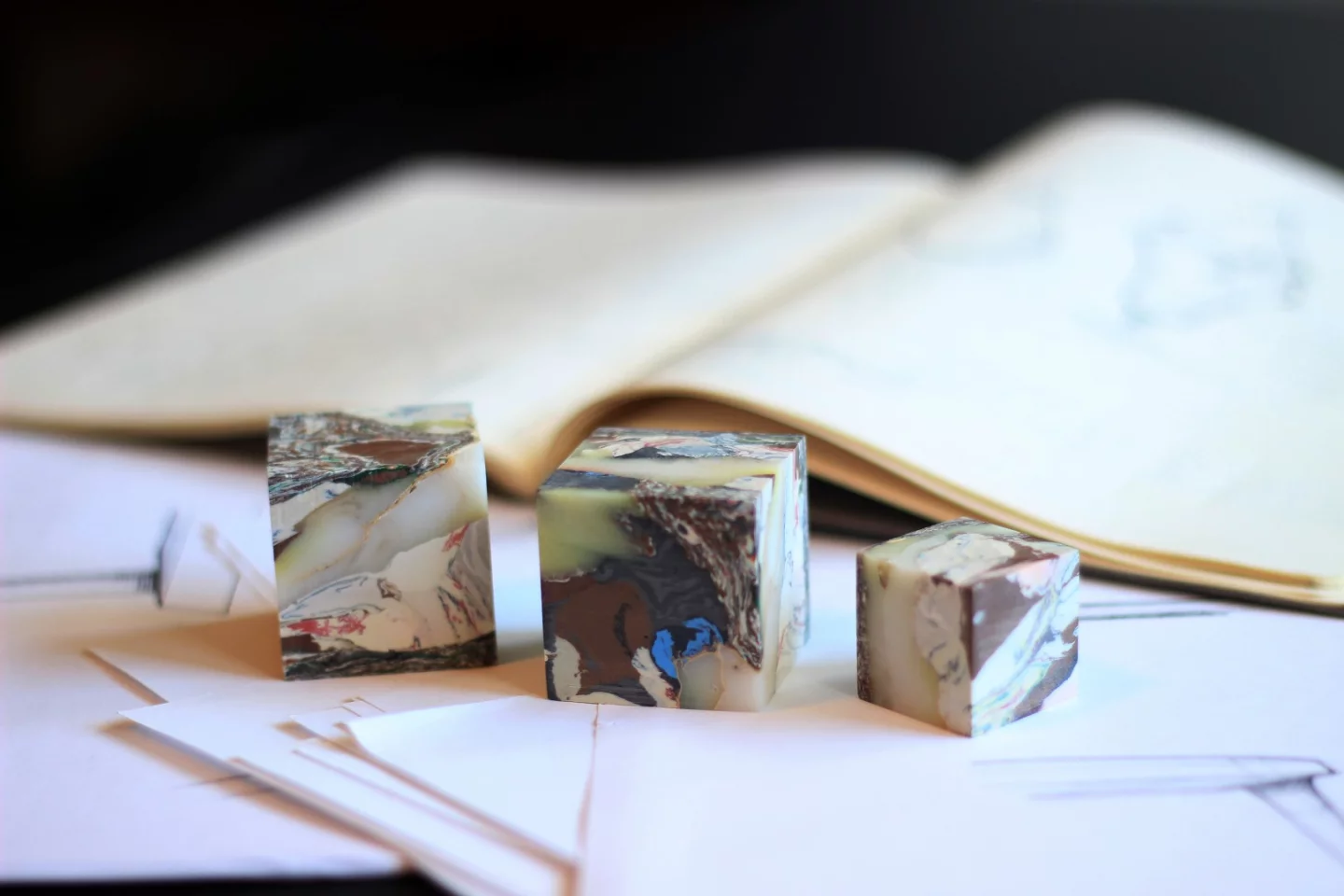 A pair of 1.5-inch cubes alongside a single 1-inch cube, each cut from a larger block of recycled plastic garbage bags