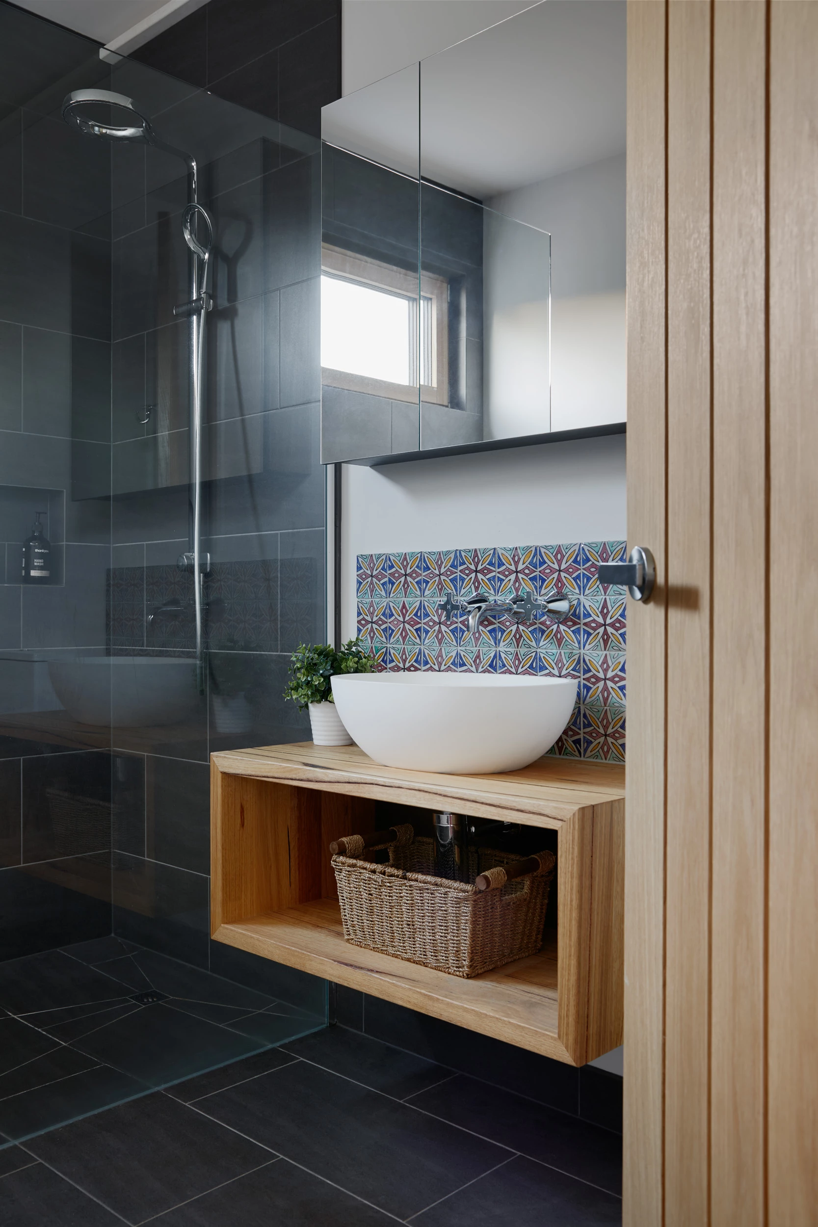 Natural gray and timber tones filter through to the bathroom interior design