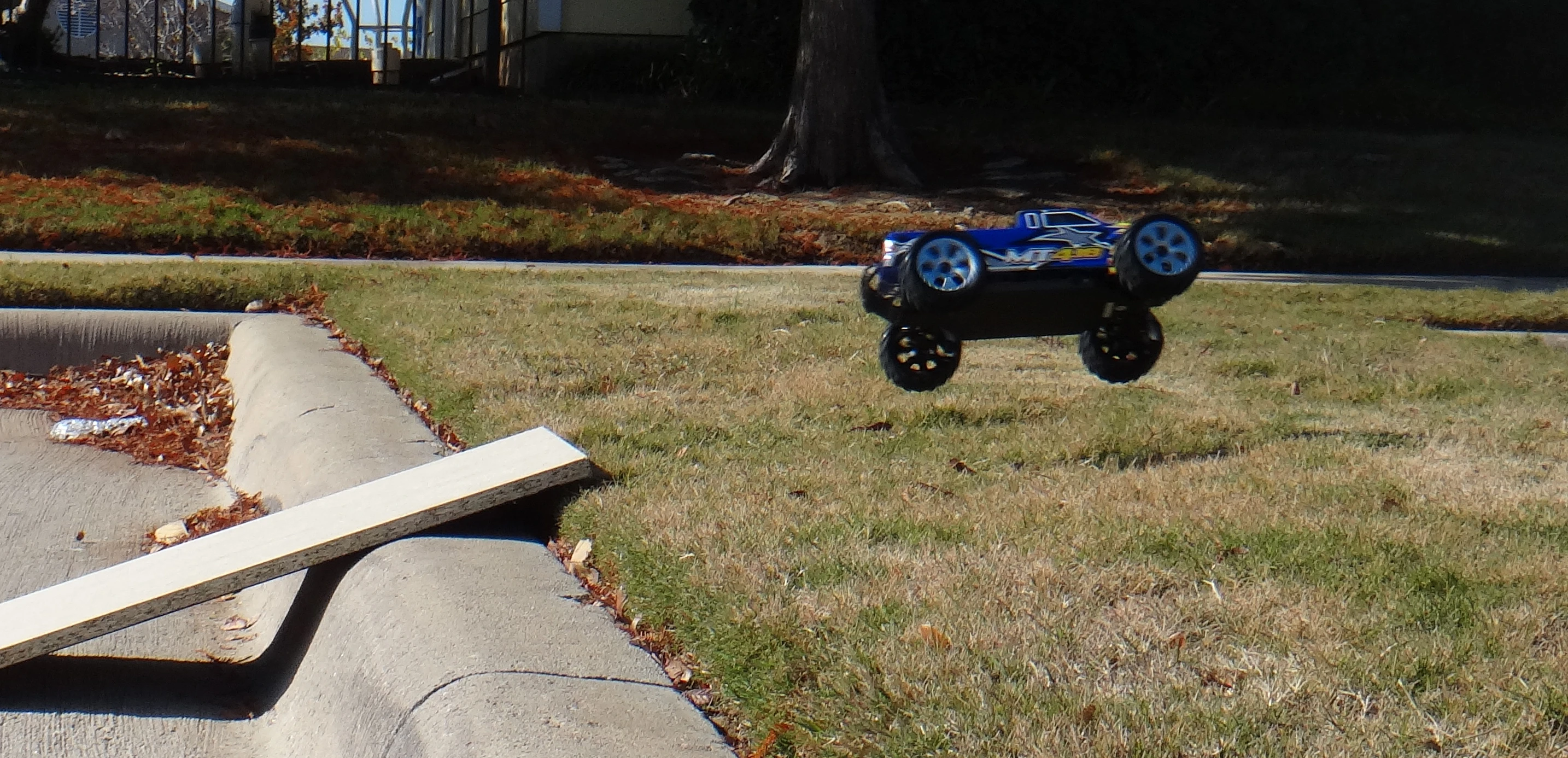 The monster truck's larger wheels are more adept at covering rougher terrain, and its narrow body helps it roll back onto its wheels after a bad tumble