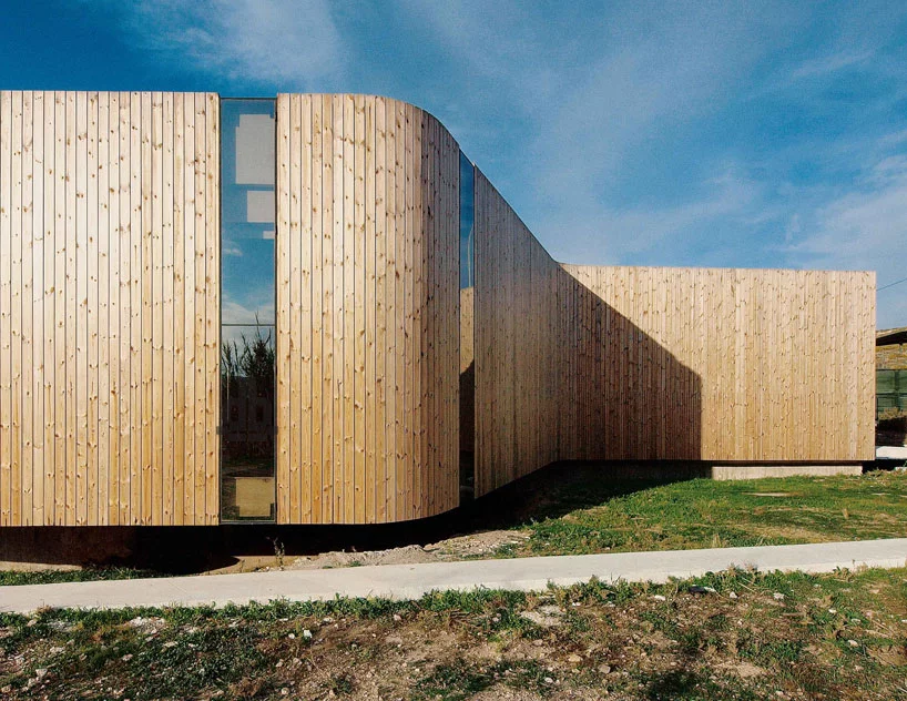 Drawing attention to the color of the ground, the rear facade is characterized by unstained natural wooden panels