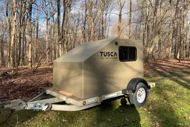 Drop it on a basic utility trailer, and the Tusca HitchHiker becomes a simple squaredrop camper
