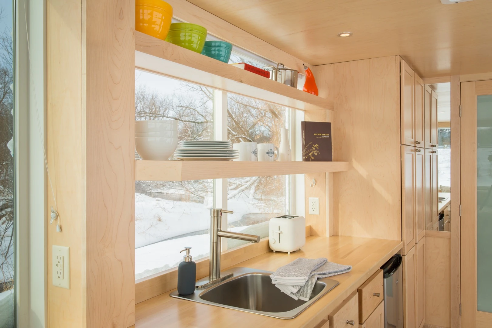The kitchen is outfitted with fridge, sink, and optional induction cooktop