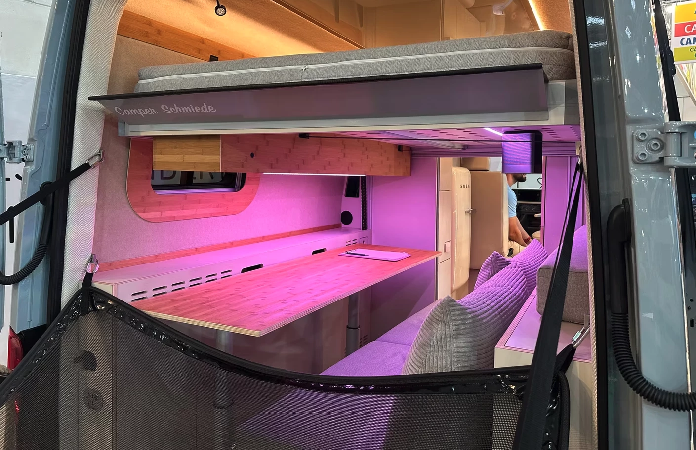 The bed slides up and down electrically into different positions above the lower workspace/sofa lounge