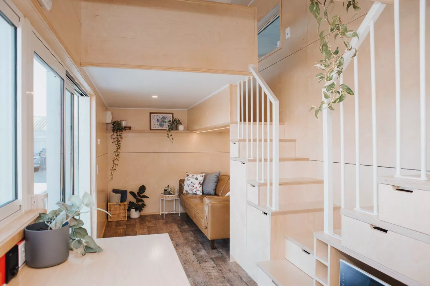Visitors enter into the living room, which includes a sofa and some shelving