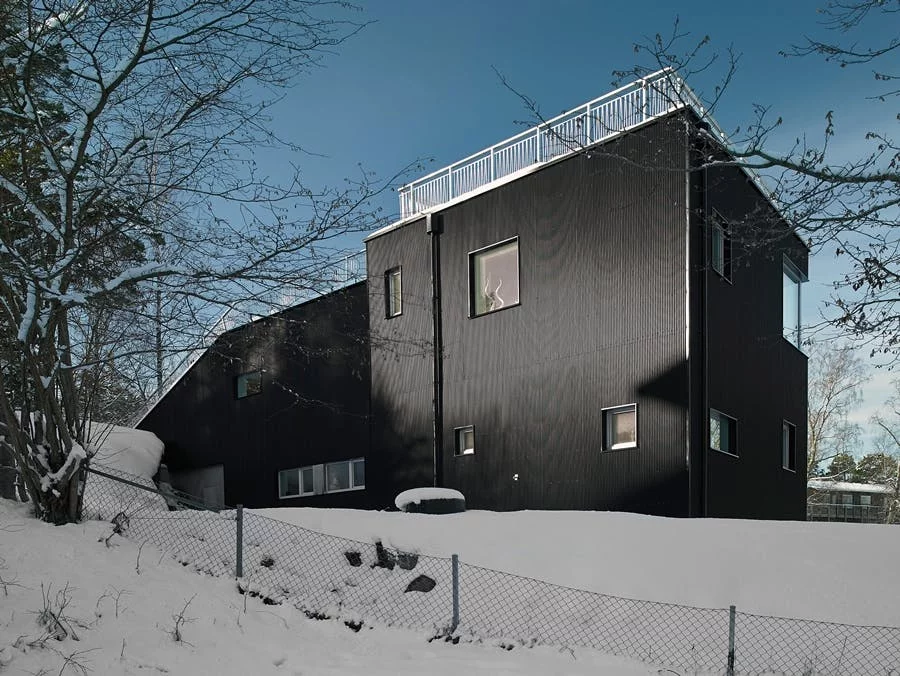 The Pulkabacken home by Street Monkey Architects in Värmdö, Sweden, featuring a large, grass-covered ground-to-roof slope that provides privacy and can be used for sledding in the snow