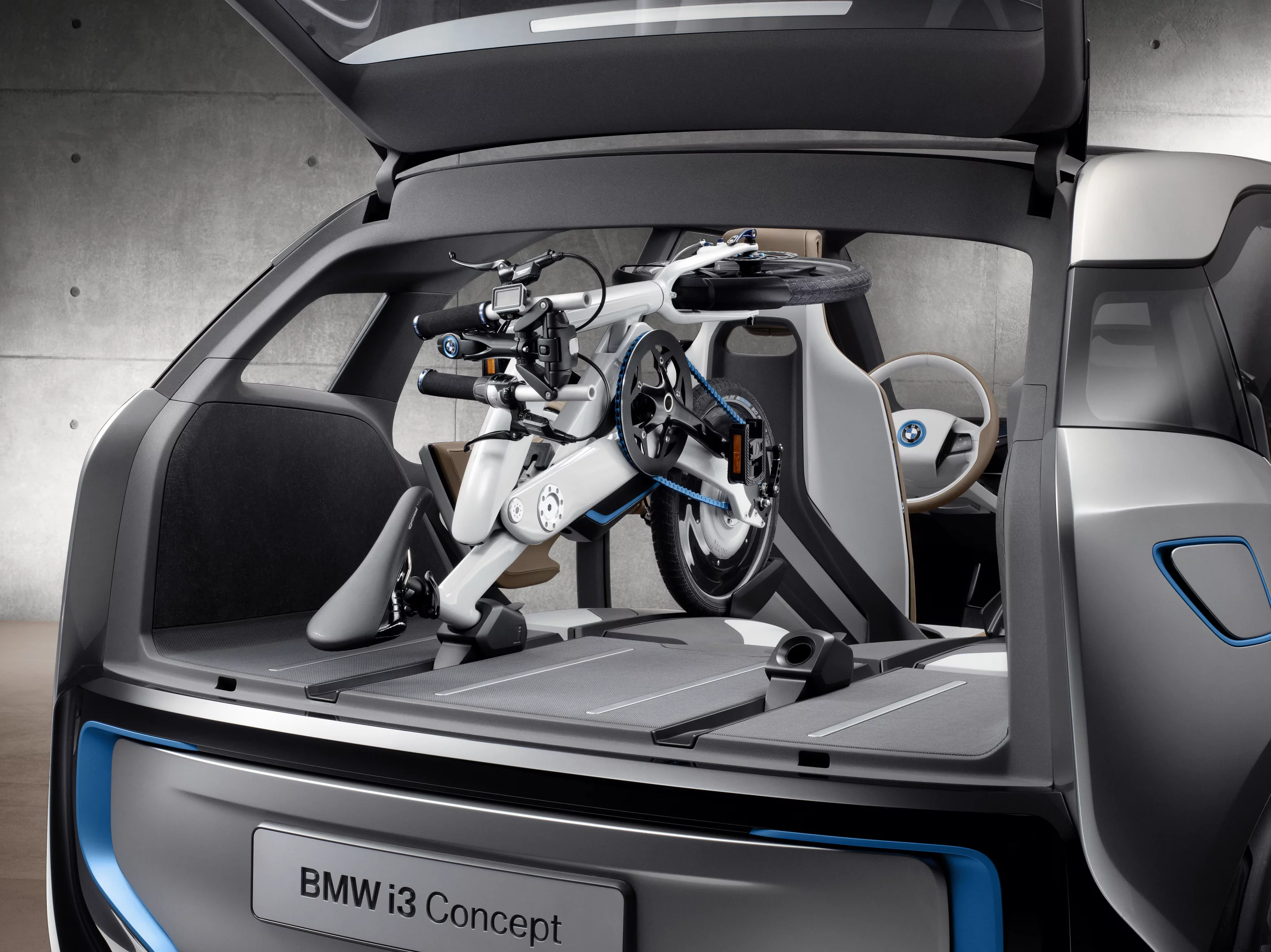 BMW says that two folded i Pedelec bikes can be comfortably squeezed into the trunk space of its forthcoming i3 EV, and that their batteries can be charged while in there