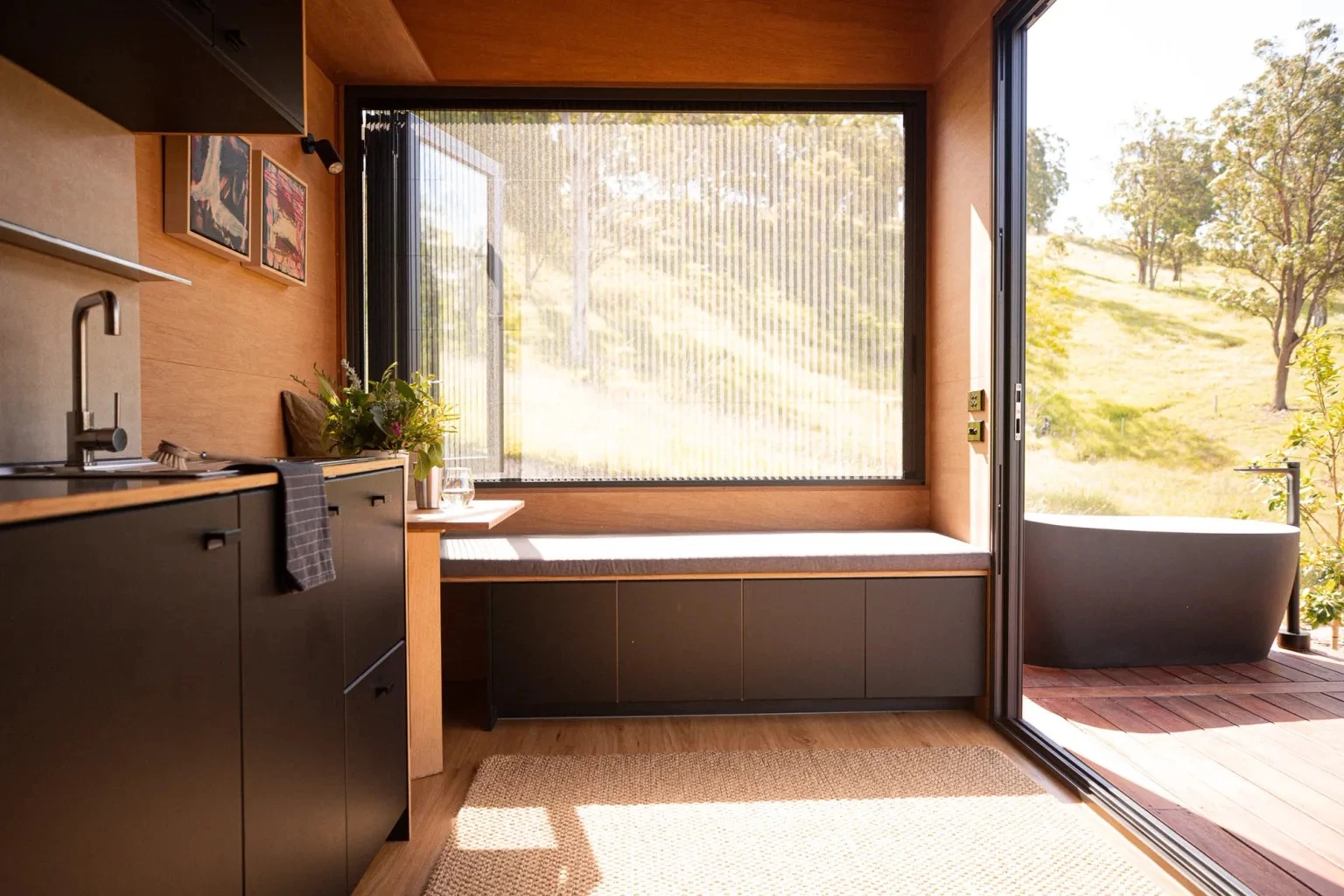The Fowler & Ward x Base Cabin's living room includes a large bench seat with integrated storage space