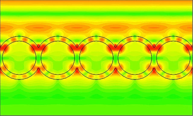 This image from a computer simulation shows how waves of light (in red/orange, traveling from the top of image to the bottom) strike a layer of nanoshells and how the light resonates within the shell structure (in red)