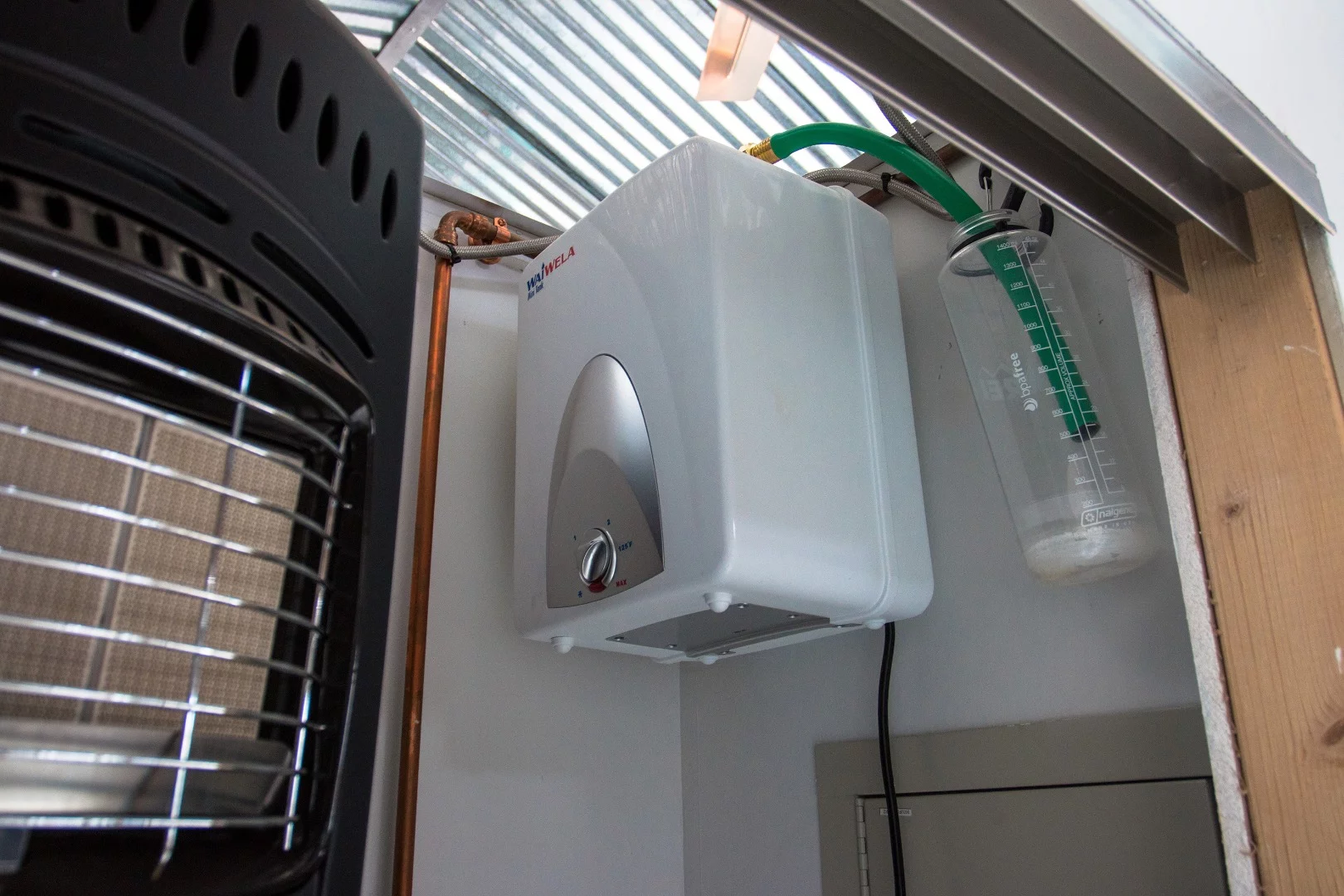 The Waiwela Mini Tank is an instant-on hot water heater that runs on electricity. It has a 1400 watt draw on his system. It's the least efficient part of his entire setup. He limits showers to just a few minutes.