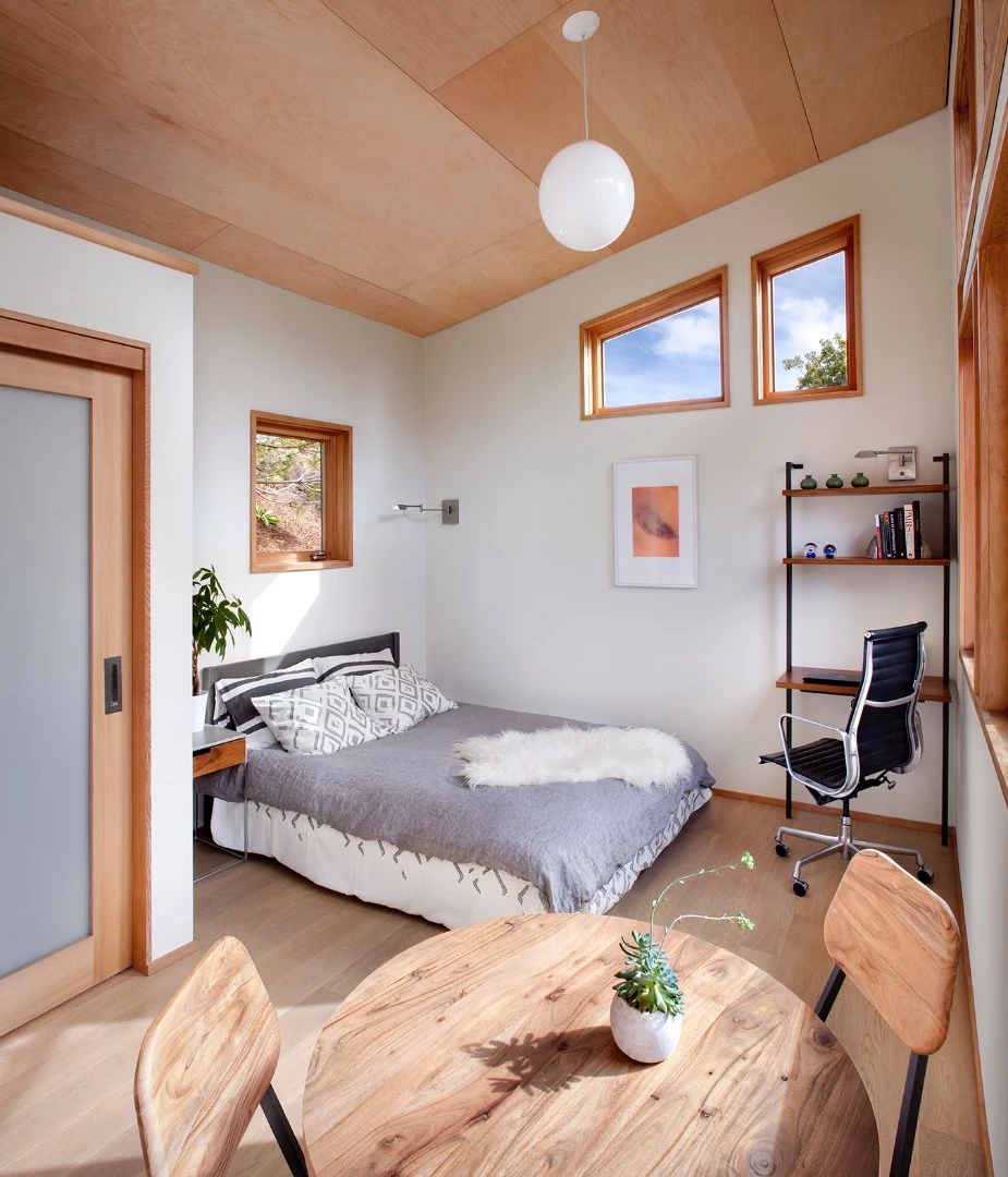 The interior includes an open living area with the lounge, dining space, kitchenette, and sleeping area