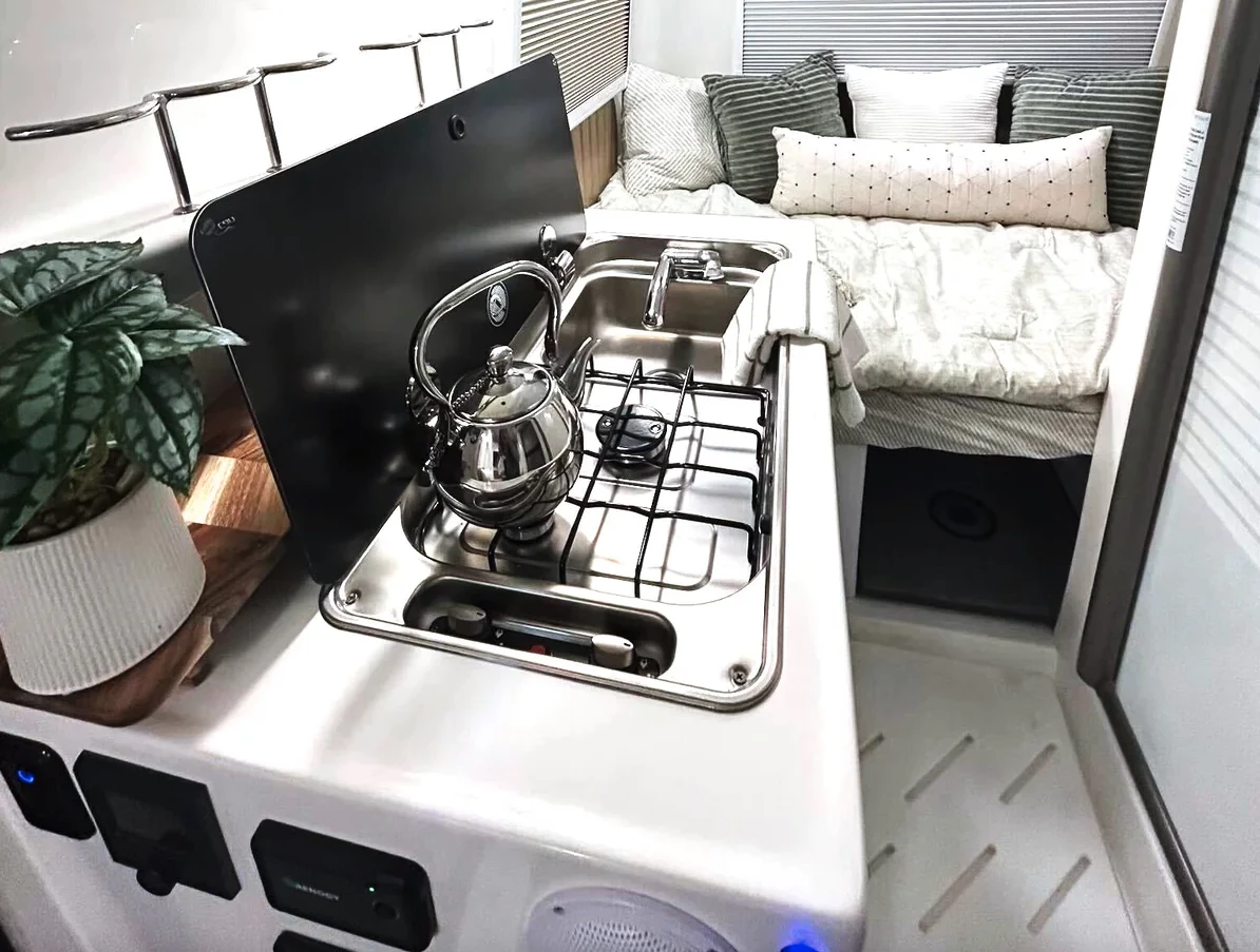 Like other Traveler models, the Summit includes a kitchen block with dual-burner gas stove or available induction cooker and sink; the new trim adds the tall fridge and microwave to the space