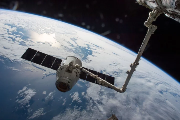 A robotic arm prepares Dragon for departure from the ISS