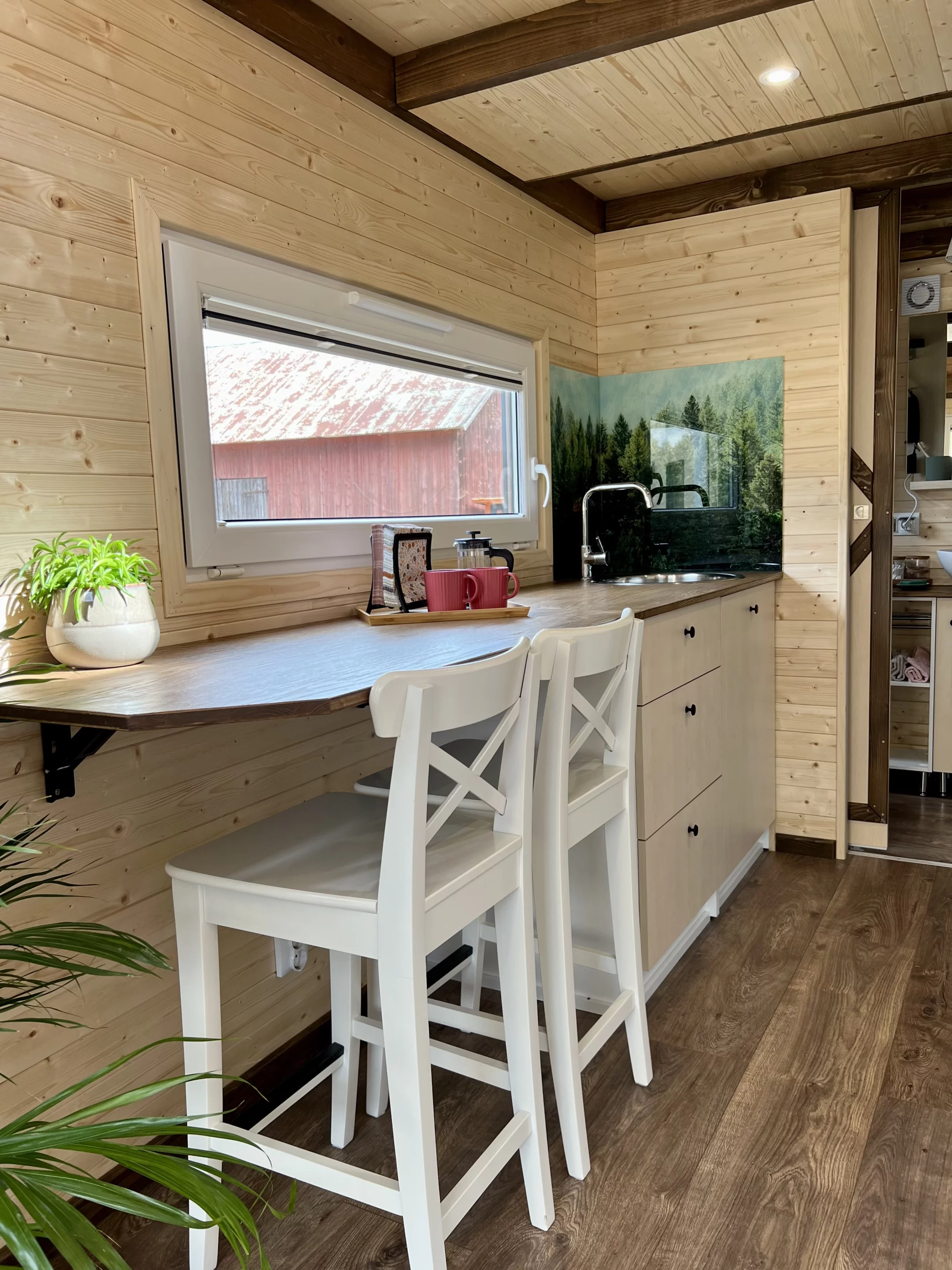 The Sunshine tiny house's kitchen includes a dining area for two people