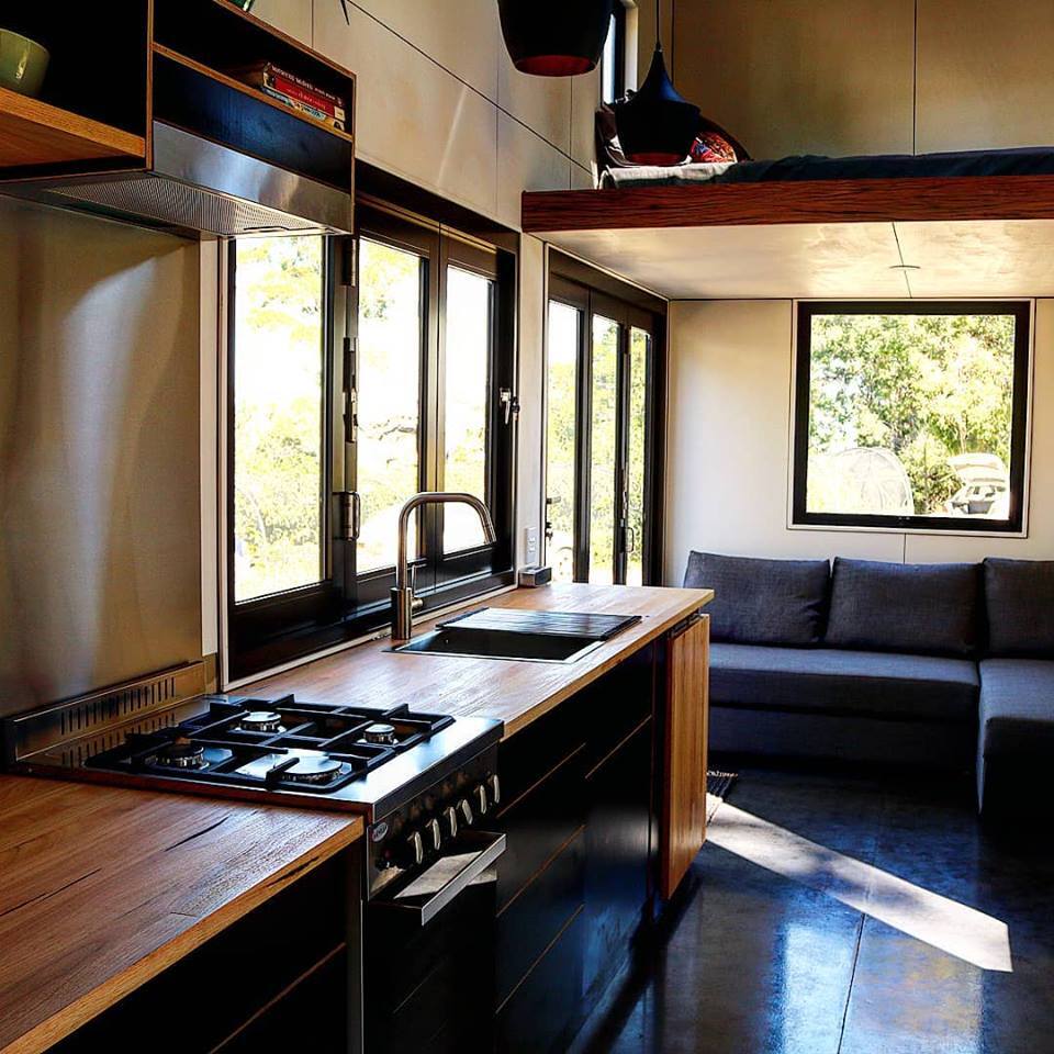 The Sowelo tiny house has a full size kitchen with stainless steel all gas stove and oven and full size energy-efficient fridge
