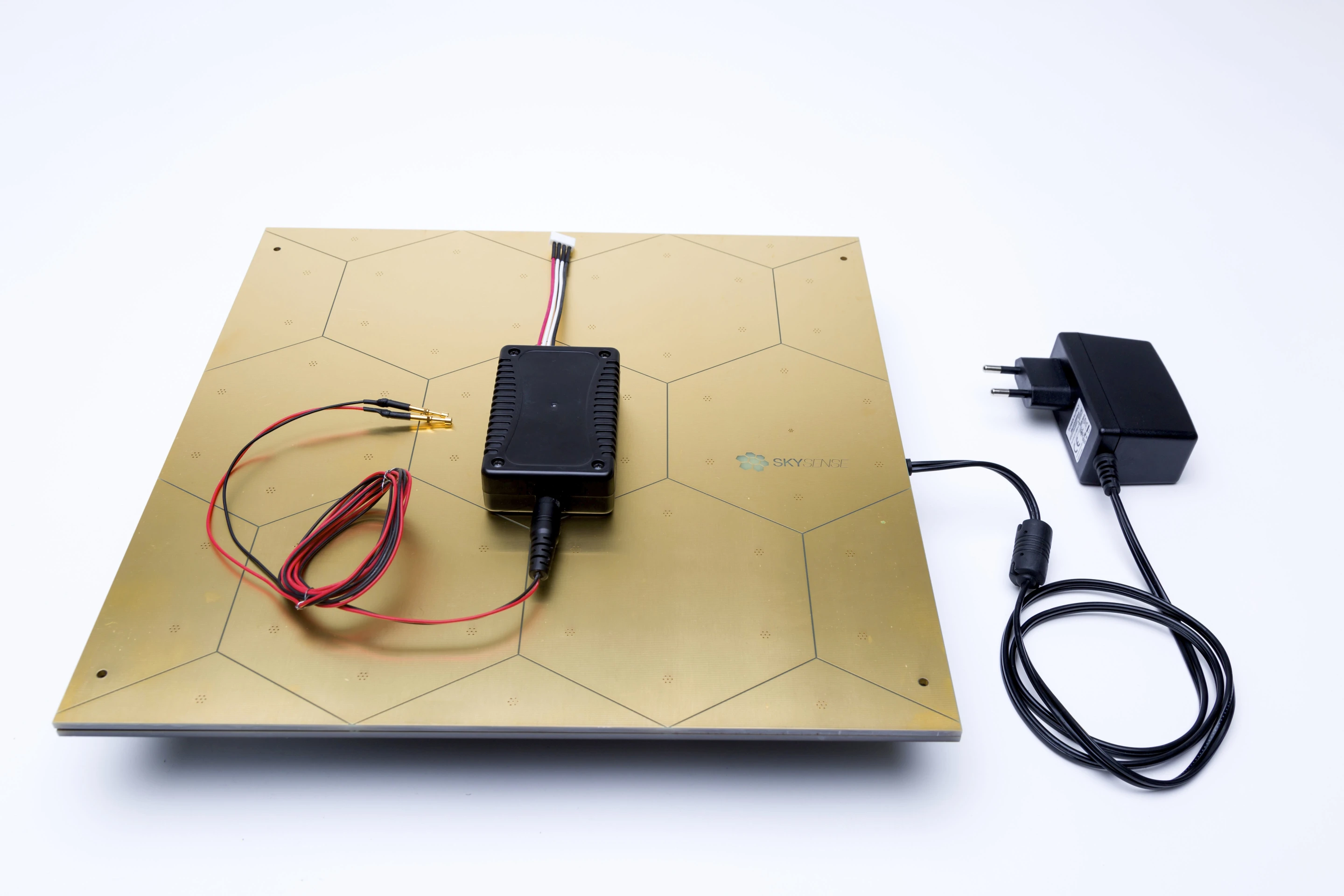 The SkySense Charging Pad is a gold-plated dock with a 100- 240 V power input and a 10 A charge rate