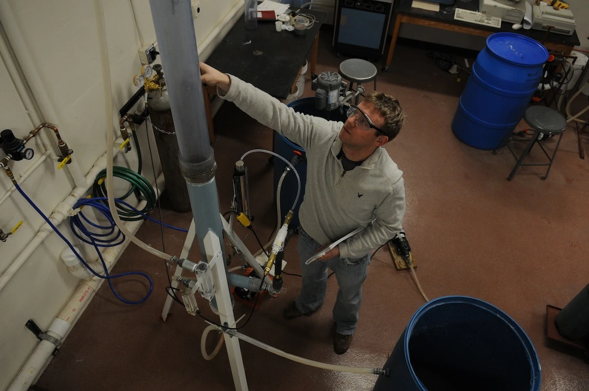 The CO2 collecting smokestack with Michigan Tech chemical engineering PhD student Brett Spigarelli (Photo: George Olszewski)